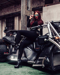 Fototapeta na wymiar stylish young woman model posing on a motorcycle exhibition.