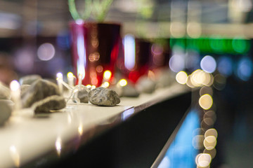 Obraz premium interior decor: small gray stones surrounded by light bulbs in soft focus