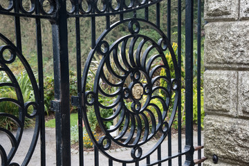 Black wrought iron gates with a circular pattern