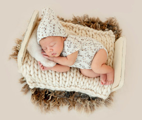Dreamy newborn baby sleeping on bed