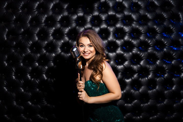 Fototapeta na wymiar Beauty Woman with retro Microphone over dark background.