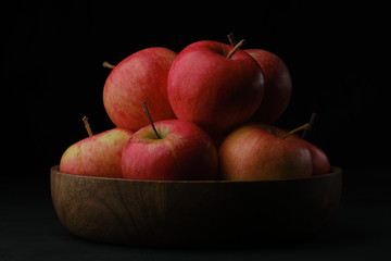 ripe red apples in wooden bowl