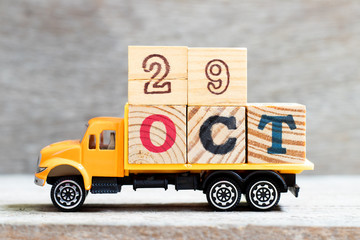 Truck hold letter block in word 29oct on wood background (Concept for date 29 month October)