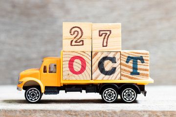 Truck hold letter block in word oct on wood background (Concept for date 27 month October)