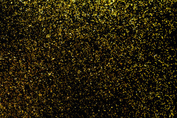 Golden glitter scattered on the black card background, top view, selective focus