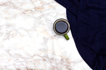 Autumn composition. Cup of coffee, blanket, blue scarf on marble table. Flat lay, top view.