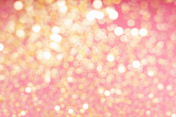 Abstract composition. Blurred photo of glitter with beautiful bokeh in pink and gold. Defocused light.