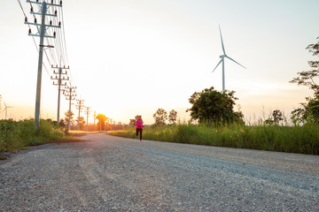 The evening sunset, The area of the wind turbine generates clean energy electricity, A woman is...