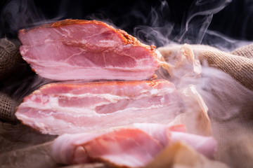 Smoked bacon in pieces. Traditional smoked cold cuts made of pork.