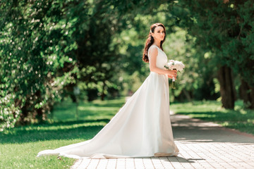 beautiful young woman in wedding dress standing in Park.