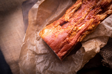 Freshly smoked and steamed bacon strips. Traditional cold cuts, made in an old-fashioned way.