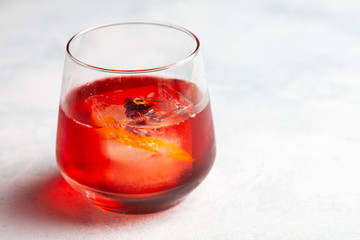 A glass of negroni on a light coloured bar top