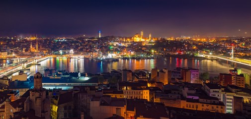Fototapeta premium Aerial panoramic night view of Golden Horn inlet and illuminated streets of Istanbul, Turkey.