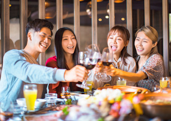 Happy friends having fun in hot pot restaurant