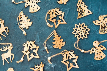 Wooden Christmas ornaments on blue background with selective focus, top view