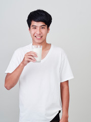 Young man holding glass of fresh milk.
