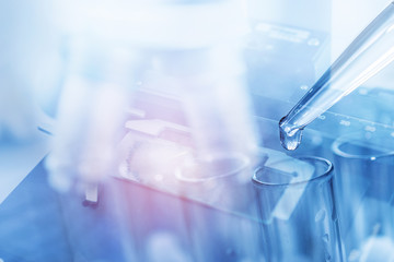 microscope with dropping liquid to test tubes, science laboratory research and development concept