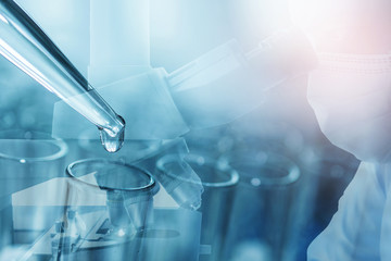 Male scientist doing microscope for chemistry test samples, examining. Laboratory equipment and science experiments, dropping liquid to test tubes