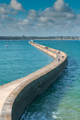 the long and winding stone harbor jetty and lighthouse in Saint-Malo