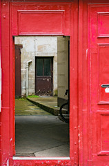bright red door opening into an inner courtyard with another door
