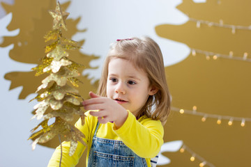 little girl with yellow christmas tree