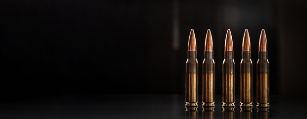 Bullet isolated on black background with reflexion. Rifle bullets close-up on black back....