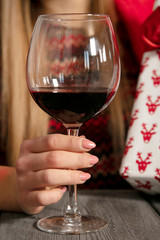 young beautiful girl wraps presents for Christmas, drinking wine