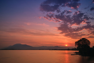 Naklejka na ściany i meble Sunrise over the lake. Reflection of the sun in the water.