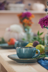 Cup of tea and flowers on the festively served autumn table  