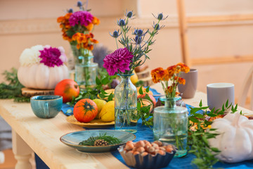 Festively served autumn table, autumn food and paraphernalia, pumpkins, flowers, tea