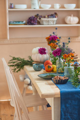 Food and autumn paraphernalia, pumpkins, flowers, tea on the festively served autumn table