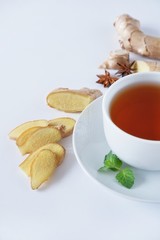 Closeup cup of black tea with ginger, mint and star anise. Therapeutic warming drink for the autumn-winter season. With space for text.