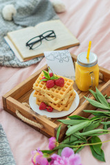 Waffles with strawberries on wood board and flowers