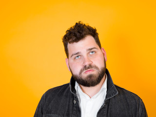Fototapeta premium one cool man with black beard and black hair is posing in front of orange background