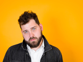 Fototapeta premium one cool man with black beard and black hair is posing in front of orange background
