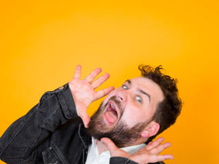 one cool man with black beard and black hair is posing in front of orange background