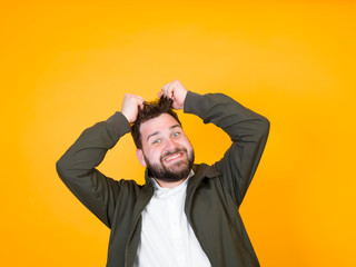 one cool man with black beard and black hair is posing in front of orange background