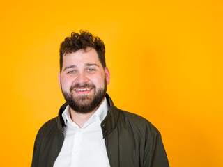 one cool man with black beard and black hair is posing in front of orange background