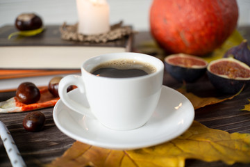 little white cup of coffee on the table in autumn style