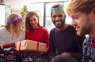 Gay Friends At Home Exchanging Gifts On Christmas Day Together