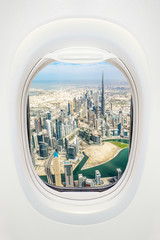 Dubai seen through the window of airplane, travel in UAE concept