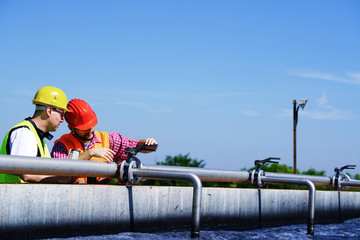Engineers controlling a quality of water ,aerated activated sludge tank at a waste water treatment plant   