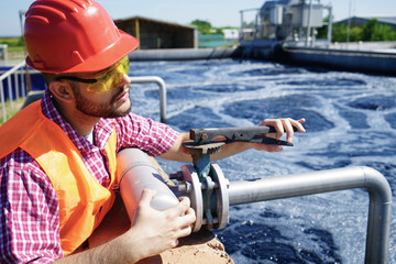 An engineer controlling a quality of water ,aerated activated sludge tank at a waste water treatment plant  