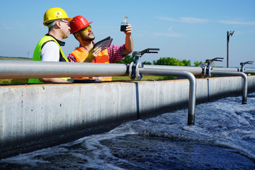                      Engineers controlling a quality of water ,aerated activated sludge tank at a waste water treatment plant 