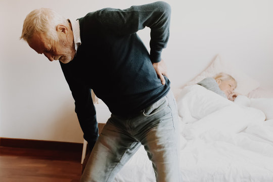 Old man with back ache clasping  . Man suffering from ribbing pain or waist pain.
