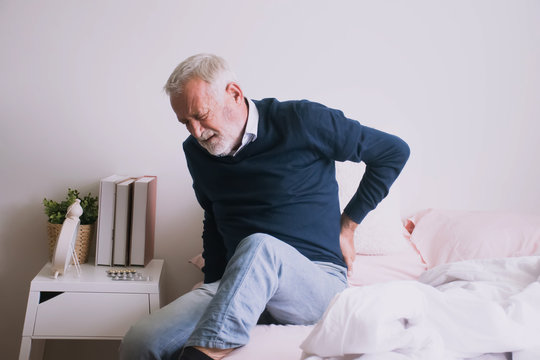 Old man with back ache clasping  . Man suffering from ribbing pain or waist pain.