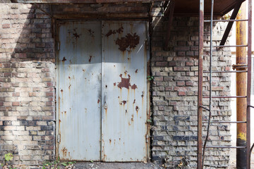 Old vintage wall with worn metal door
