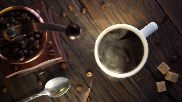 Coffee cup with freshly brewed coffee on an old vintage table. Steam rises from the cup.
