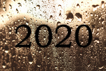 Wet glass with 2020 on glass. Concept begins the new year 2020.