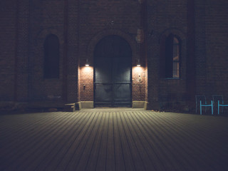 Dim lights in front of big metal doors at night. Location: Turku, Finland.